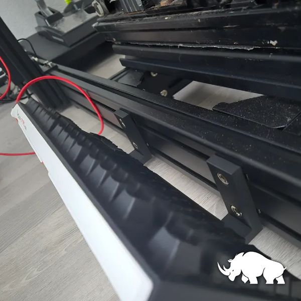 Teclado desmontado apoyado sobre su soporte, diseñado para ajustarse a la estructura de un simulador de carreras con perfiles de aluminio.